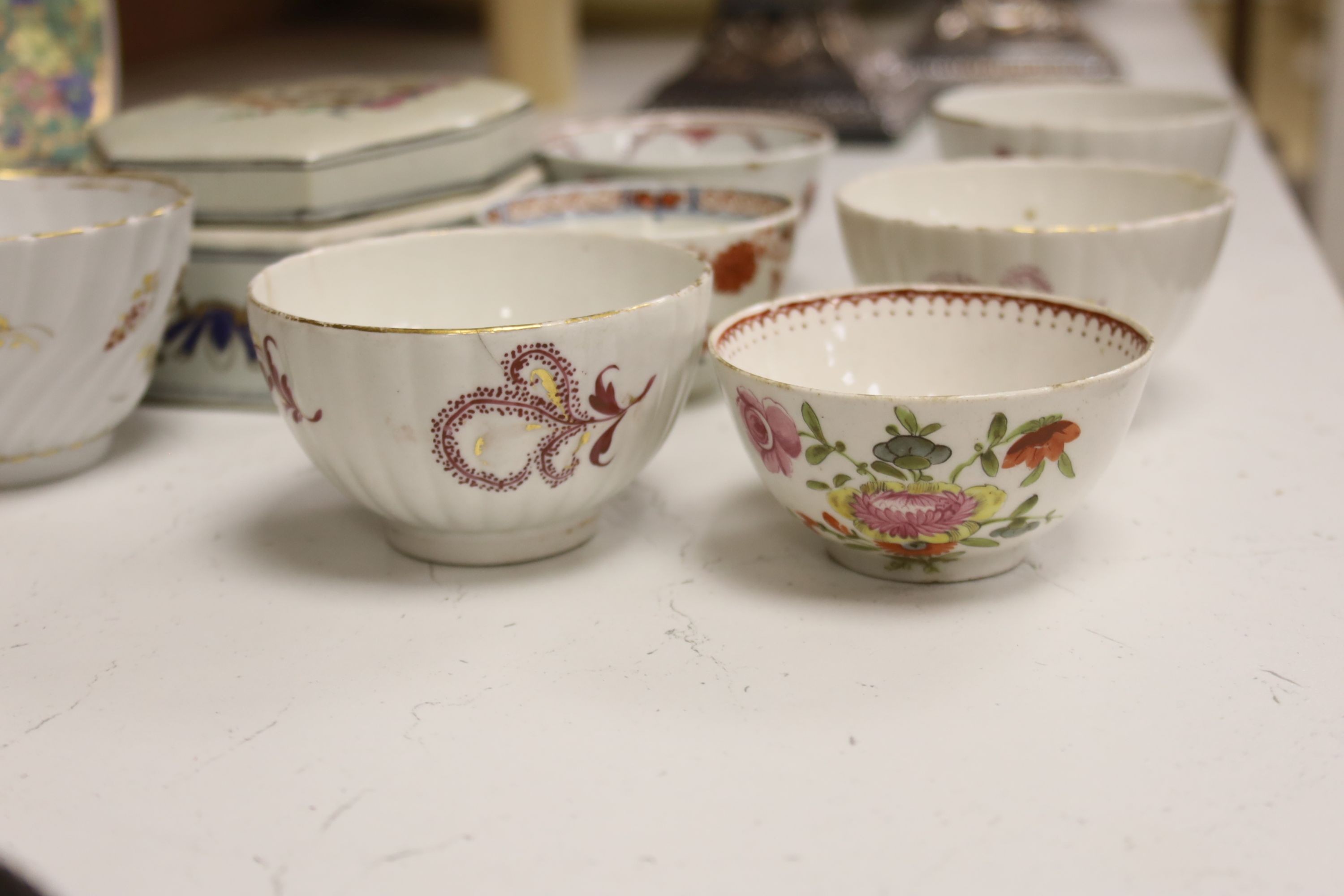 Seven 18th century English porcelain tea bowls, an armorial box and cover and a famille rose dish, diameter 30cm